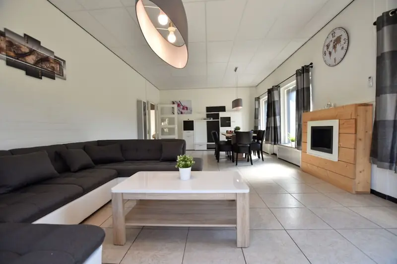 Langer Wohnraum mit Ecksofa und Couchtisch, am Ende der Essbereich.